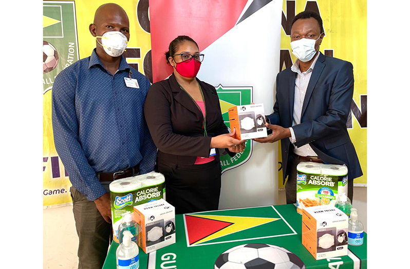 : GFF Executive Committee Member Dion Innis (first from right), receiving the donation from Muneshwers Secretary Priscilia Ramcharran, while Richard Coddett, Health, Safety, Security and Environment Manager looks on.