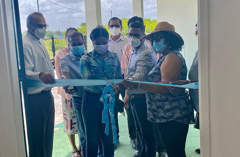 Community Health Officer, Verelyn Small, cuts the ribbon to officially open the Health Centre in the presence of Minister of Health, Dr. Frank Anthony (left) and other officials