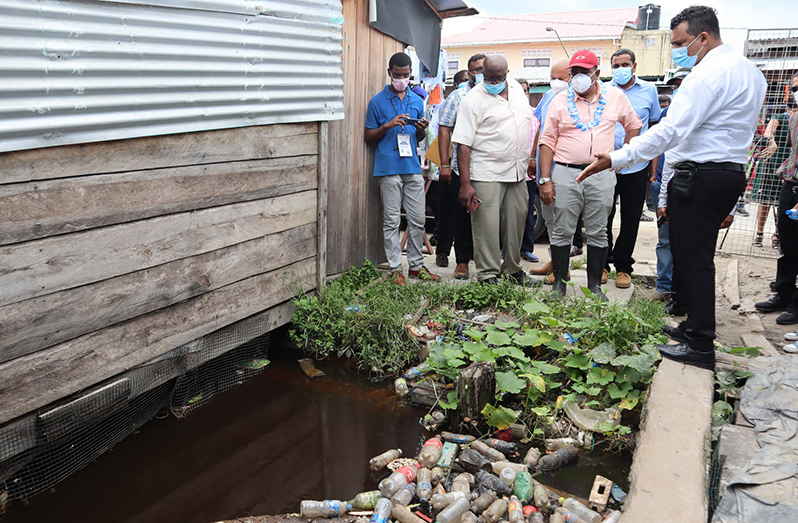 Prime Minister Mark Phillips (partly hidden) and Agriculture Minister, Zulfikar Mustapha inspecting a clogged drain during a recent visit to Charity (Ministry of Agriculture photo)