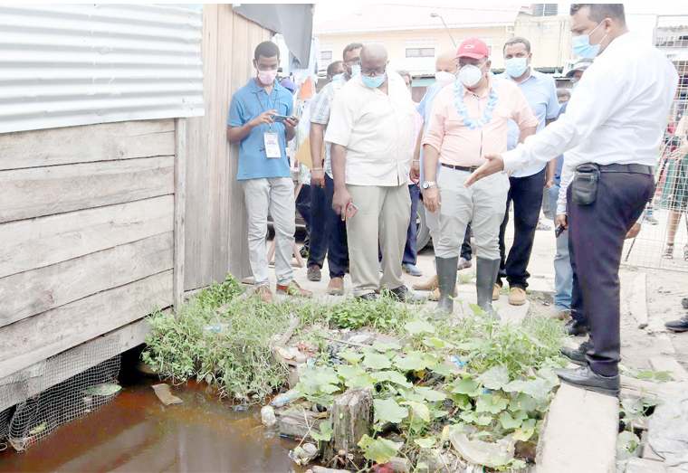 Prime Minister Mark Phillips (partly hidden) and Agriculture Minister, Zulfikar Mustapha inspecting a clogged drain during a recent visit to Charity (Ministry of Agriculture photo)