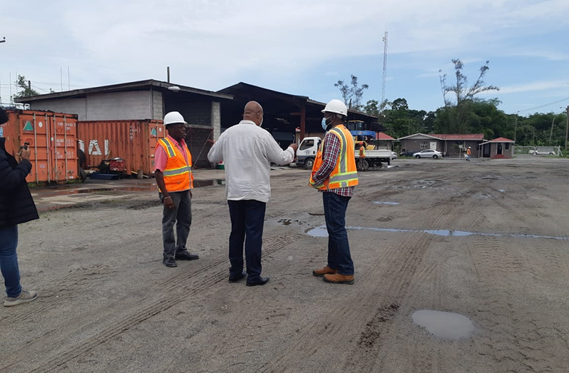 Minister Edghill engaging Manager of the Asphalt Plant, Troy Halley (right) along with another employee