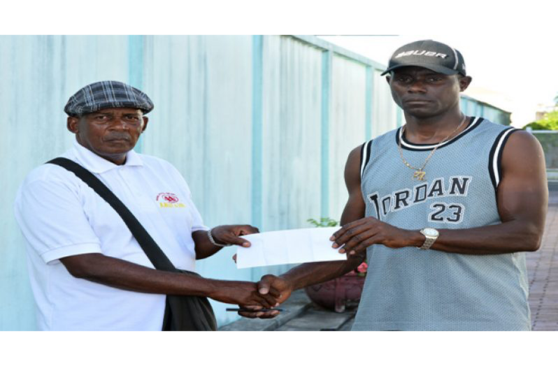 Flashback! Randolph Roberts (left) accepts the sponsorship cheque for the 50-mile race from former national cyclist Wilbert Benjamin back in 2016.