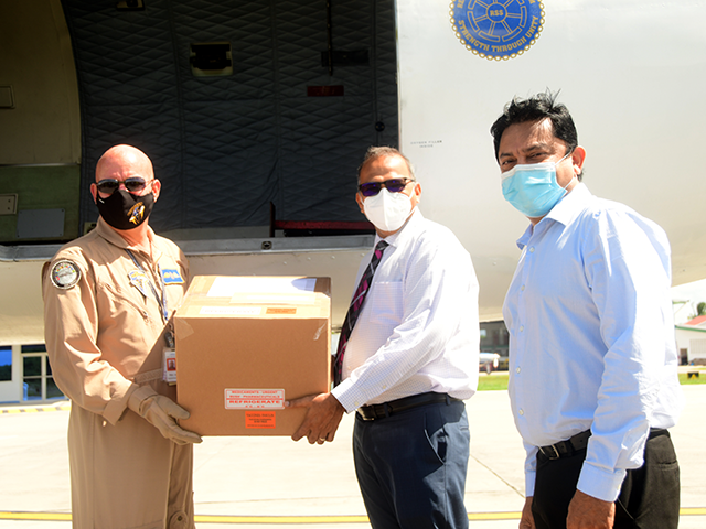 Minister of Health, Dr Frank Anthony (second right) and Chief Medical Officer, Dr Narine Singh, collect the vaccines, donated by Barbados to Guyana, at the Ogle Airport, on the East Coast of Demerara (Adrian Narine photo)
