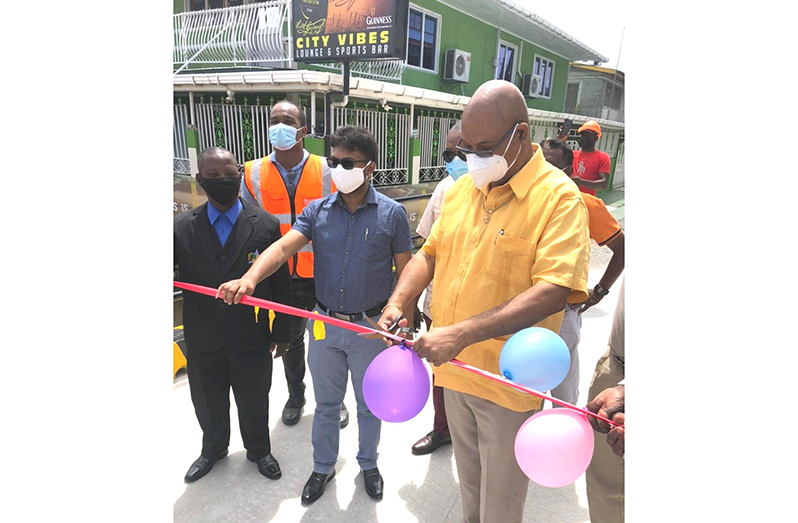 Public Works Minister, Juan Edghill, cuts the ribbon to officially open the new bridge in the presence of Mayor Ubraj Narine and Constituency Councillor, Heston Bostwick