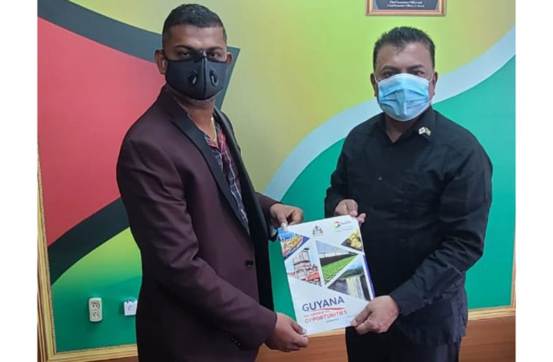 Owner of Caribbean Concrete Guyana, Amar Chetram (left) and Chief Executive Officer (CEO) of the Guyana Office for Investment (Go-Invest), Dr. Peter Ramsaroop hold up a signed copy of the Memorandum of Understanding
