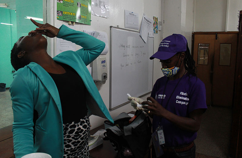 A staffer at the Guyana Chronicle taking her filaria pills as part of the Mass Drug Administration (MDA) campaign to eliminate lymphatic filariasis