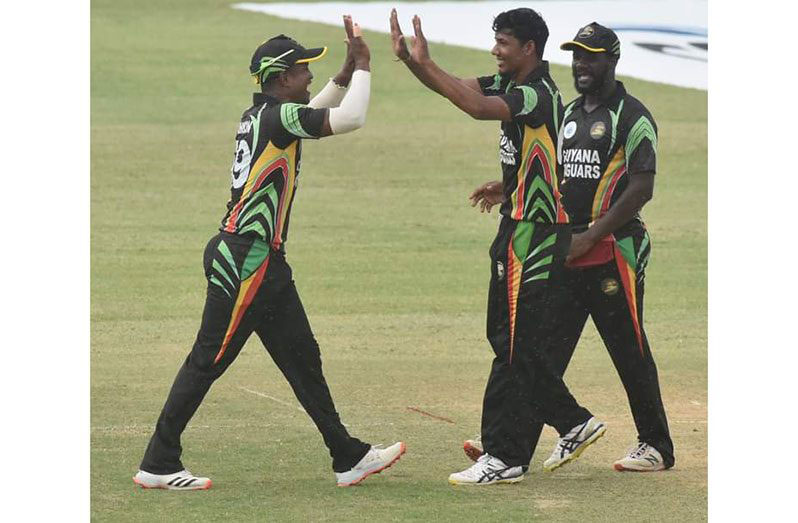 Gudakesh Motie celebrates a wicket with Guyana captain Leon Johnson and Ramaal Lewis.