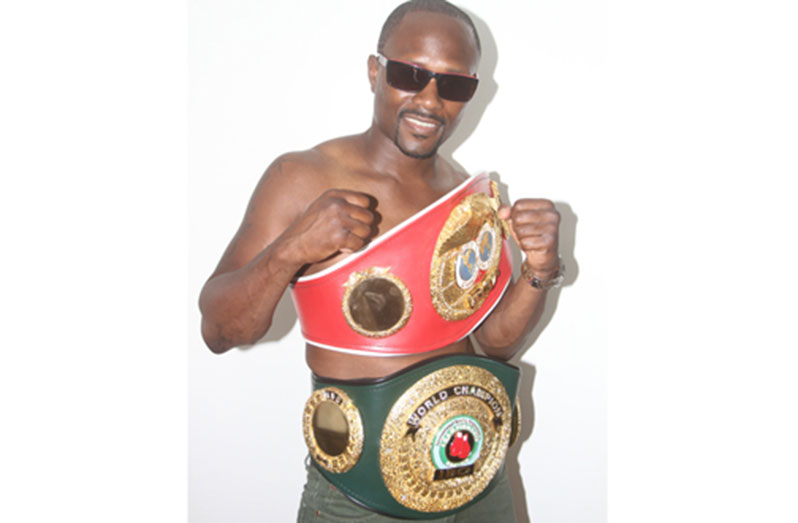 Gairy St Clair wears his two world title belts.