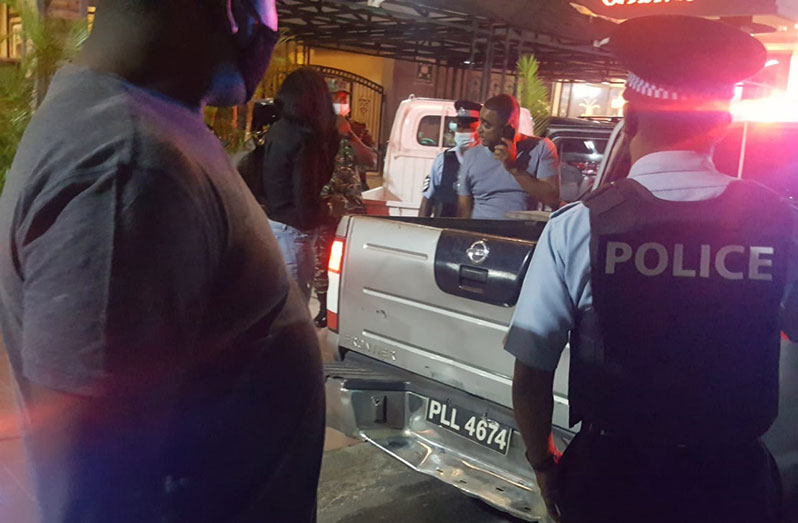Officers of the armed forces detaining the SleepIn Hotel and Casino proprietor, Clifton Bacchus, on Saturday night