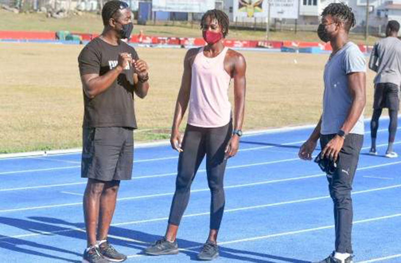 Damon Williams (right) of Guyana along with St Lucia's Sandisha Antoine (centre) listen keenly to head coach Kerry-Lee Ricketts during a training season at the Usain Bolt track at UWI last week. (Photos: Collin Reid)