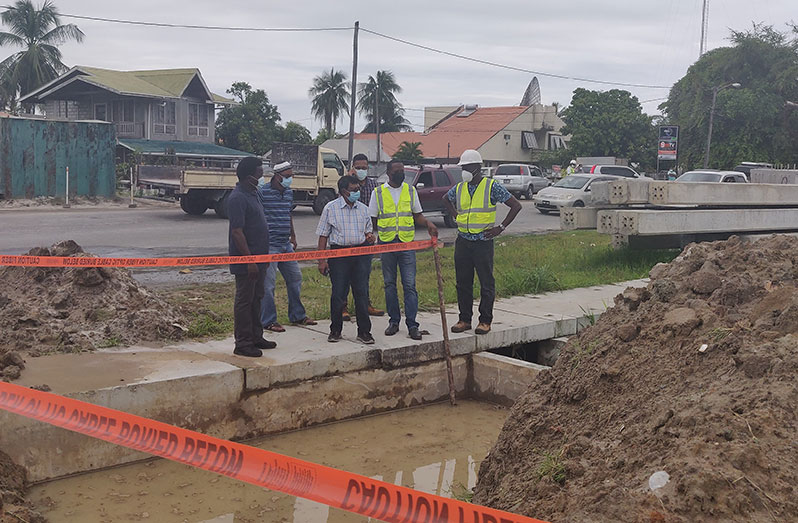 GWI's Chief Executive Officer Shaik Baksh and technical officials assess works to be undertaken on Mandela Avenue