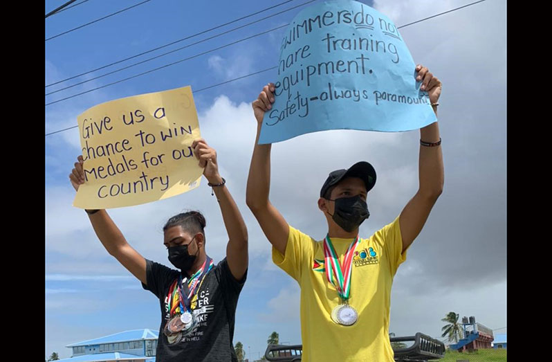 National swimmers Stephen and Stephon Ramkhelawan (brothers), and members of the Dorado Swim Club, proudly display their medals during yesterday’s protest.