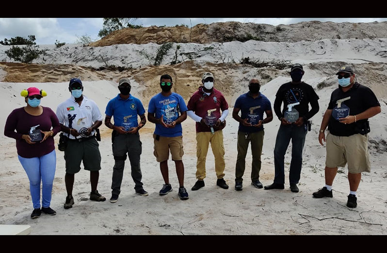 Eight of the top nine shooters of the Orinduik Development Inc. & Aquafina GuyanaNRA Smallbore Action Pistol Match display their trophies.