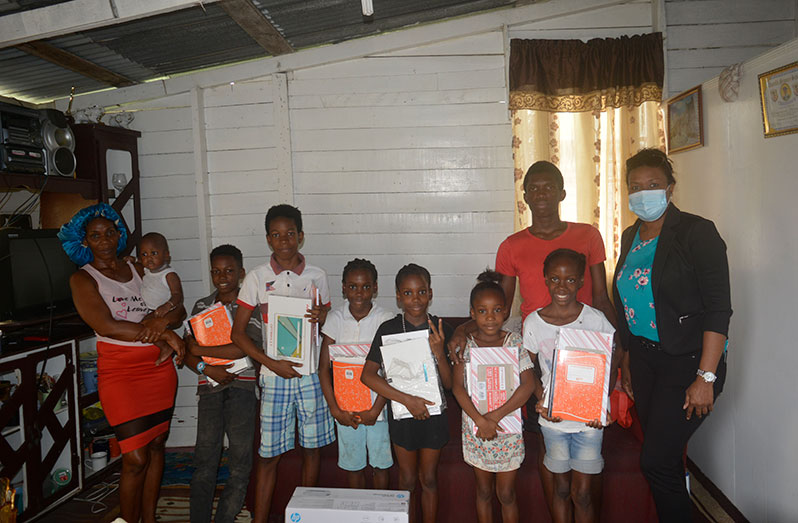 The children with some of the items they received from Smart Start. Also pictured are their mother, Yvonne Reid-Hamilton (far left), and Manager of Smart Start, Gillian Singh (far right)