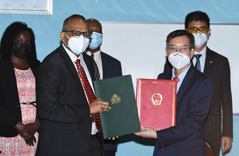 Health Minister, Dr. Frank Anthony, and Chargé d’Affaires of the Embassy of the People’s Republic of China, Chen Xilai hold the documents signed to acknowledge the receipt of China-donated Sinopharm vaccine (Adrian Narine photo)