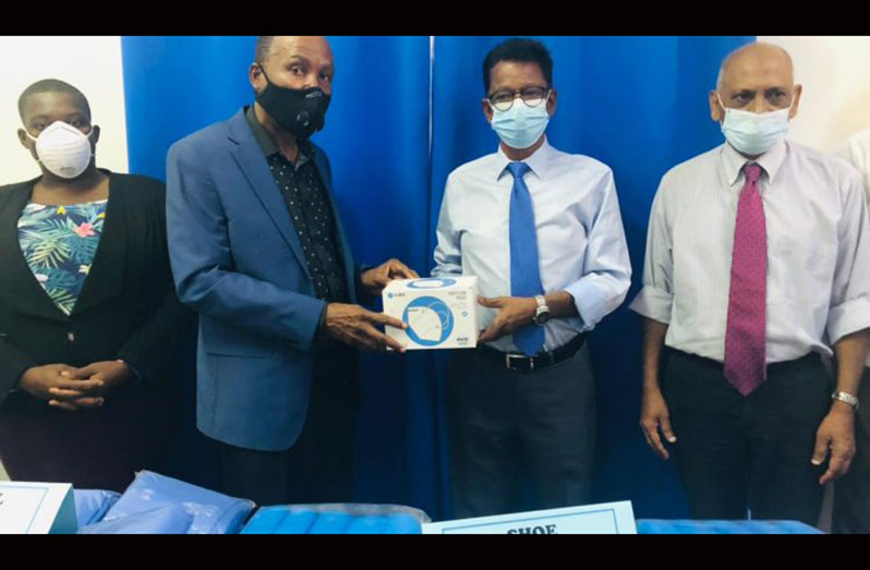 Second from left: Apostle Elsworth Williams hands over the items to Chairman of the Board of Georgetown Hospital, Dr. Madan Rambarran. Dr. Leslie Ramsammy is standing at the right (GPHC photo)