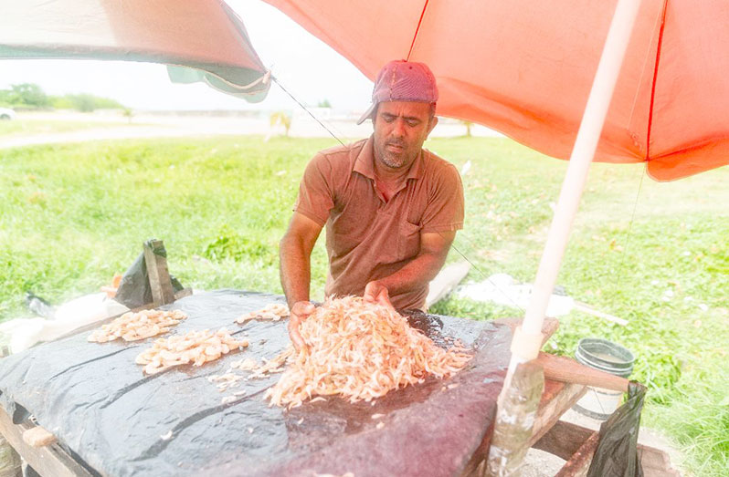 A vendor parcelling shrimp for sale