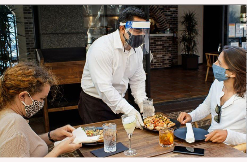 Restaurant employees observe the COVID-19 protocols, which have become the new ‘norm’ (Photo courtesy of Getty Images)