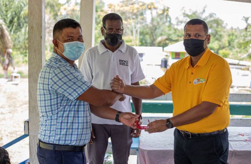 Minister of Housing and Water, Collin Croal, officially handing over the keys to the boat and engine to Deputy Toshao of Batavia, Murphy Gomez