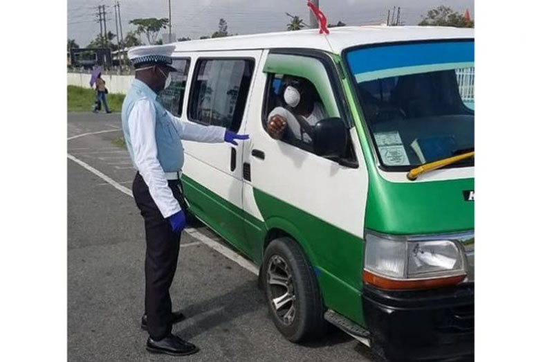 A police officer chats with a minibus driver recently (GPF photo)