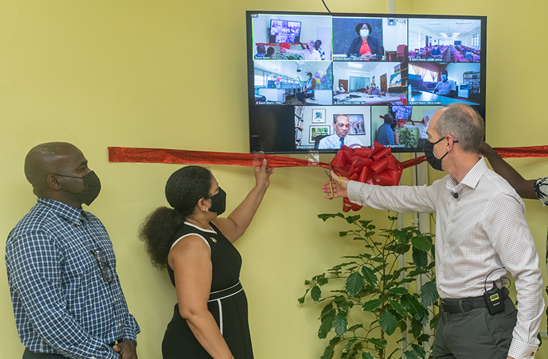 President of Exxon Mobil Guyana, Alistair Routledge, proceeds to cut the ribbon to officially launch the ZOOM Room project in the presence of Vice-Chancellor Professor Paloma Mohamed-Martin and special invitees