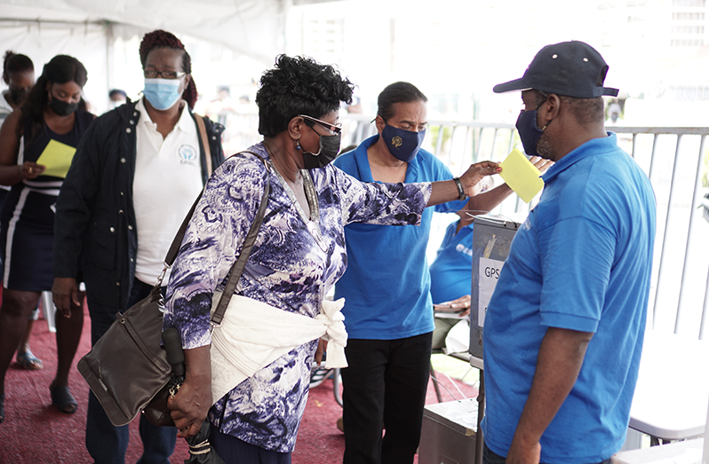 A GPSCCU member deposits her ballot after casting her vote (Elvin Croker photo)