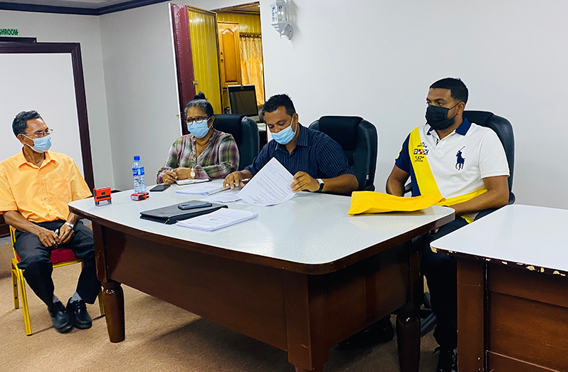 Regional Executive Officer (REO), Devanand Ramdatt, takes a look at the contract document. Also pictured, from left, are PPP/C councillor, Lloyd Perriera, Regional Chairperson Vilma De Silva, and Managing Director of N and M Trucking and Security Service, Narsurdeen ‘Junior’ Mohammed