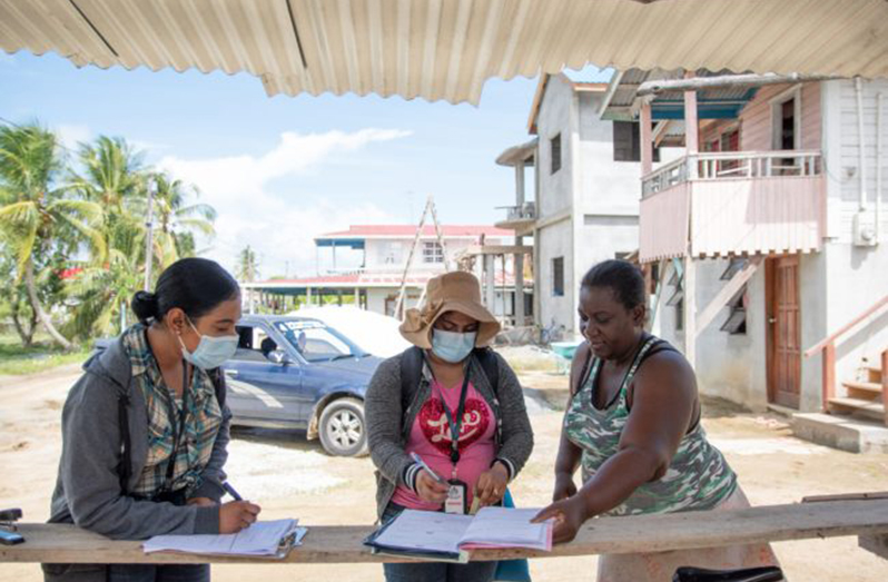Distribution clerks present this resident with her cash grant (DPI photo)