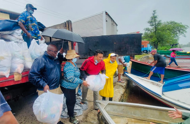 Regional Executive Officer, Devanand Ramdatt; Regional Vice-Chairman, Humace Oodit; Regional Chairperson, Vilma De Silva and the Prime Minister's Representative, Arnold Adams loading a boat with supplies for Charity