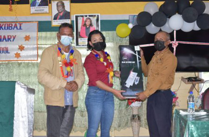 Minister within the Ministry of Housing and Water Susan Rodrigues and Member of Parliament Faizal Jaffarally, handing over streetlights to Moraikobai Toshao, Derrick John