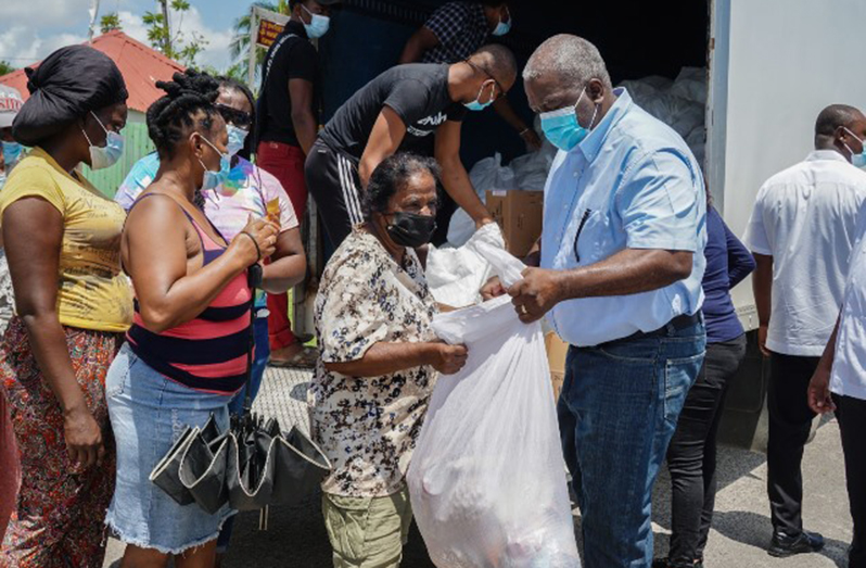 Prime Minister Brigadier (ret’d) Mark Phillips distributes food hampers to residents of Albouystown and Kingston