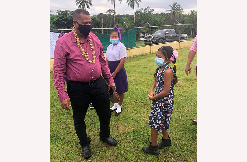 Housing and Water Minister, Collin Croal, being greeted upon his arrival at Waramuri on Saturday