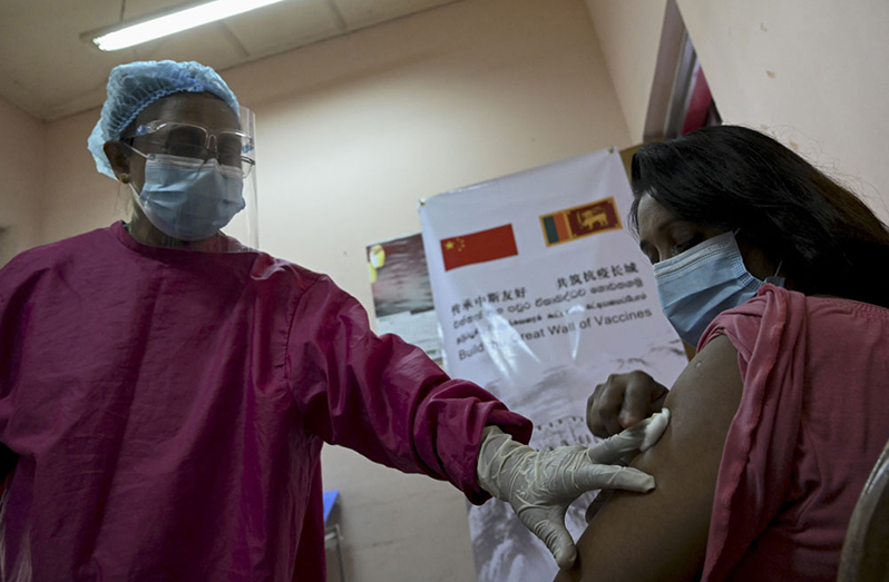 health worker checks a woman who received a dose of the China-made Sinopharm COVID-19 vaccine in Panadura, a suburb of Sri Lanka's capital, Colombo, on Saturday. ISHARA S. KODIKARA/AFP