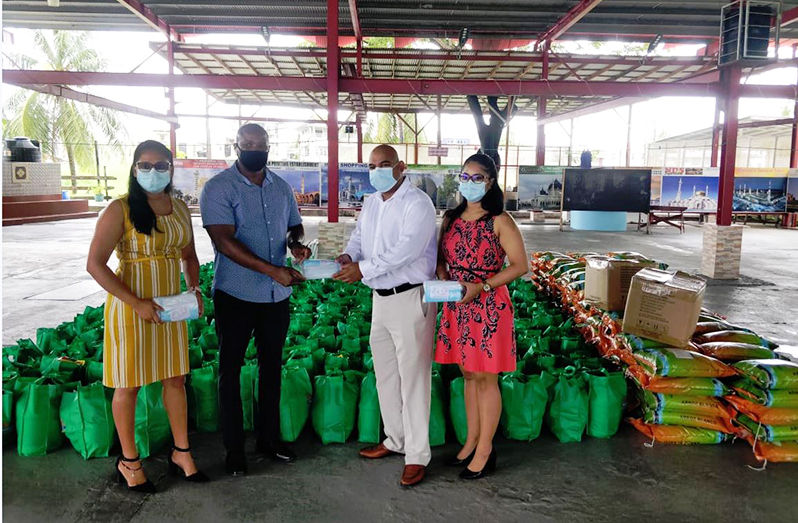 Ravindra Prashad (right) and other representatives of Readymix Concrete and Palm Court hand over the items to a representative of CDC