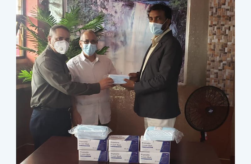 Cuba’s Ambassador to Guyana, Narciso Reinaldo Armador Socorro (centre), oversees the donation of 5,000 face masks from GCSM President, Halim Khan (at right) to Head of the Cuban Medical Brigade, Ruiz Arcia Ineldo