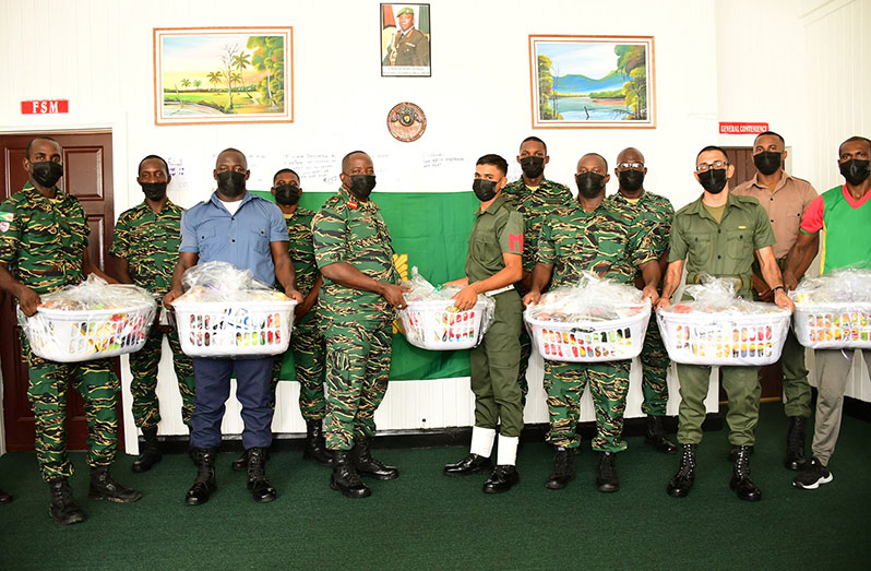 Chief-of-Staff (ag), Brigadier Godfrey Bess, presents a hamper to one of the many soldiers in observance of Father’s Day