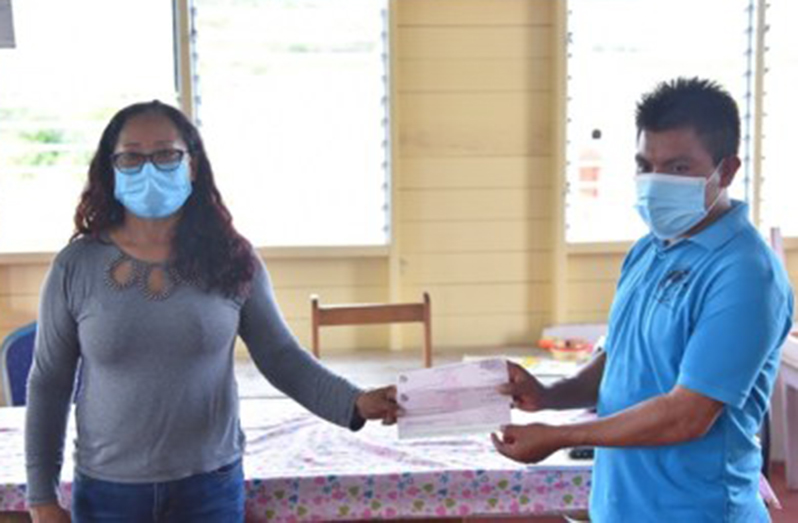 Amerindian Affairs Minister, Pauline Sukhai, hands over a cheque to Toshao of Phillipai, Mark Joseph (DPI photo)