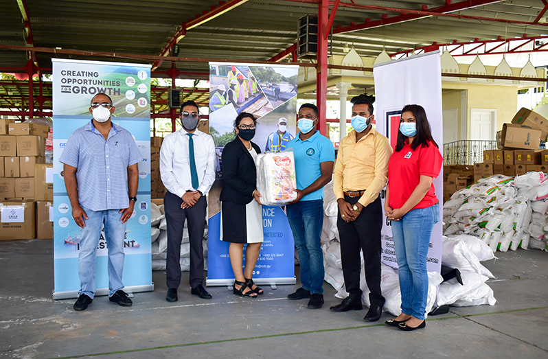 Canada-Guyana Chamber of Commerce’s CEO, Natalia Seepersaud, handing over some of the items to Civil Defence Commission, Public Relations Officer, Patrice Wishart, as others look on