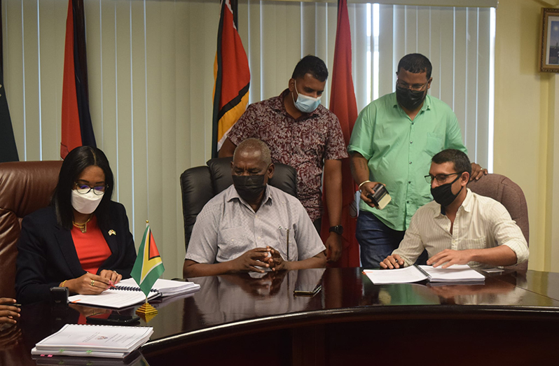 Signing on behalf of the Home Affairs Ministry was Permanent Secretary, Mae Toussaint Jr. Thomas (left) in the presence of Home Affairs Minister, Robeson Benn and one of the contractors