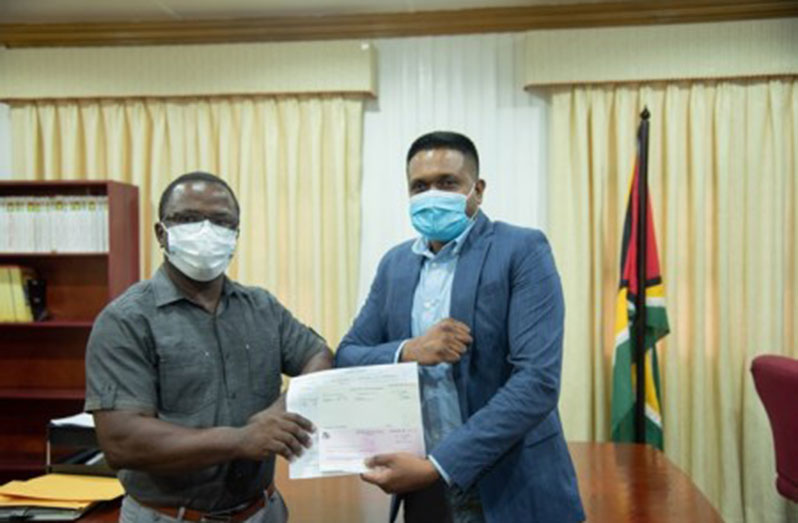 Local Government and Regional Development Minister Nigel Dharamlall hands over a subvention cheque to representatives of the Industry/Plaisance NDC