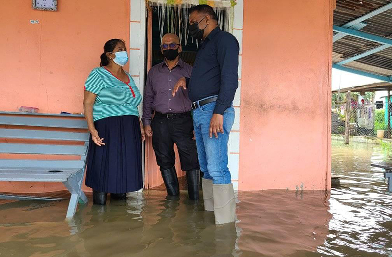 Minister Deodat Indar and Region Three’s Regional Chairman, Ishan Ayube, speaking to one of the affected residents (Ministry of Public Works photo)