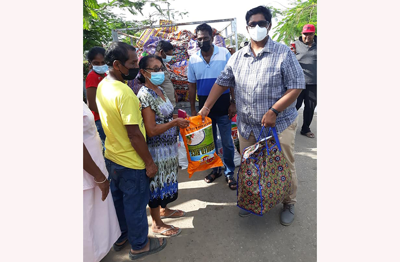Vitality Accounting and Consultancy Inc.’s representative, President of Golden Om Dharmic, Pandit Deodat Persaud, distributing the hampers to flood- affected citizens of Branch Road, Mahaicony