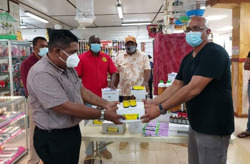 Agriculture Minister, Zulfikar Mustapha, receiving veterinary supplies from a representative of Poonai's Pharmacy and General Store