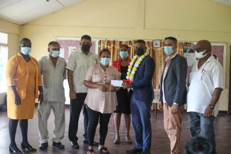 Minister within the Ministry of Public Works, Deodat Indar, distributes the ‘Because We Care’ grant in Region Three (DPI photo)