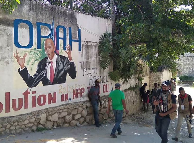 People walk past a wall with a mural depicting Haiti's President Jovenel Moïse, after he was shot dead by unidentified attackers in his private residence, in Port-au-Prince, Haiti (REUTERS/Robenson Sanon)