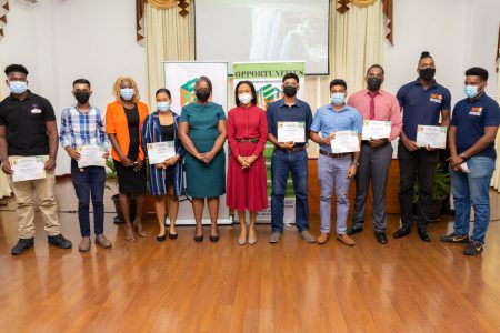 Tourism, Industry and Commerce Minister, Oneidge Walrond, along with the 12 awardees (DPI photo)