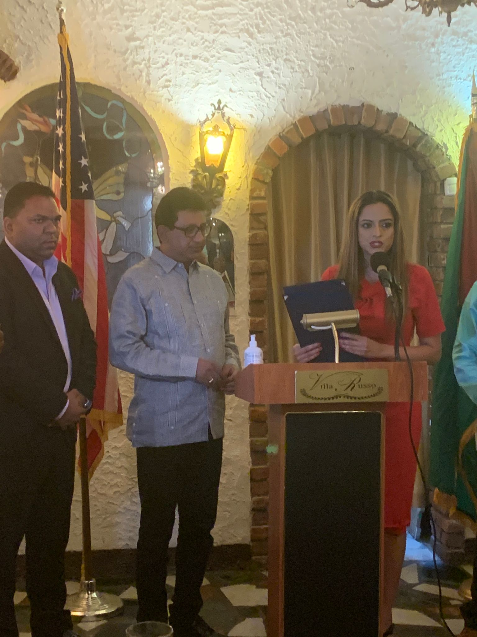 Attorney-General Anil Nandlall listens to Jenifer
Rajkumar of the New York State Assembly before
being presented with a citation for his role in protecting
the rights of Guyanese. Romeo Hitlal, at
left, looks on