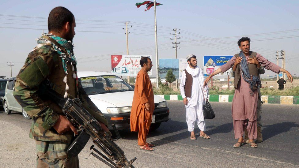 Afghan soldiers search a man at a checkpoint in Herat province. The army has lost ground to the Taliban (BBC photo)