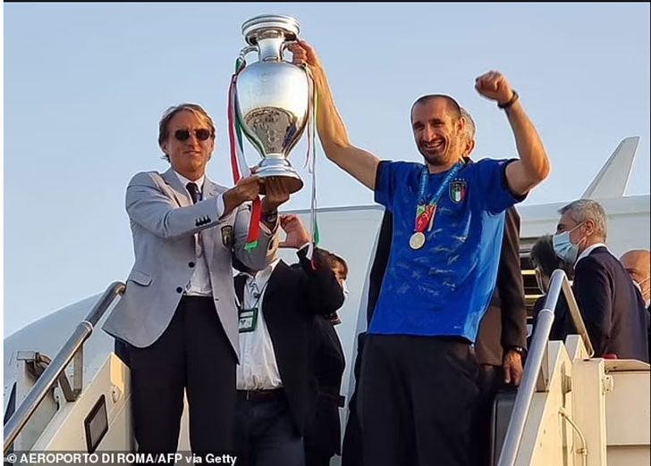 Roberto Mancini lifts the trophy alongside Giorgio Chiellini as Italy arrive back in Rome. (AFP photo)