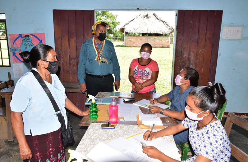 Minister of Housing and Water, Collin Croal, interacts with persons and parents involved in the “Because We Care” distribution exercise